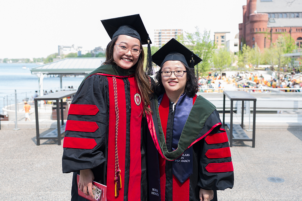 PharmD Class of 2022 graduates Lorewell Buaya and Kathy Chao pose together on Memorial Union Terrace following the 2022 Hooding Ceremony.