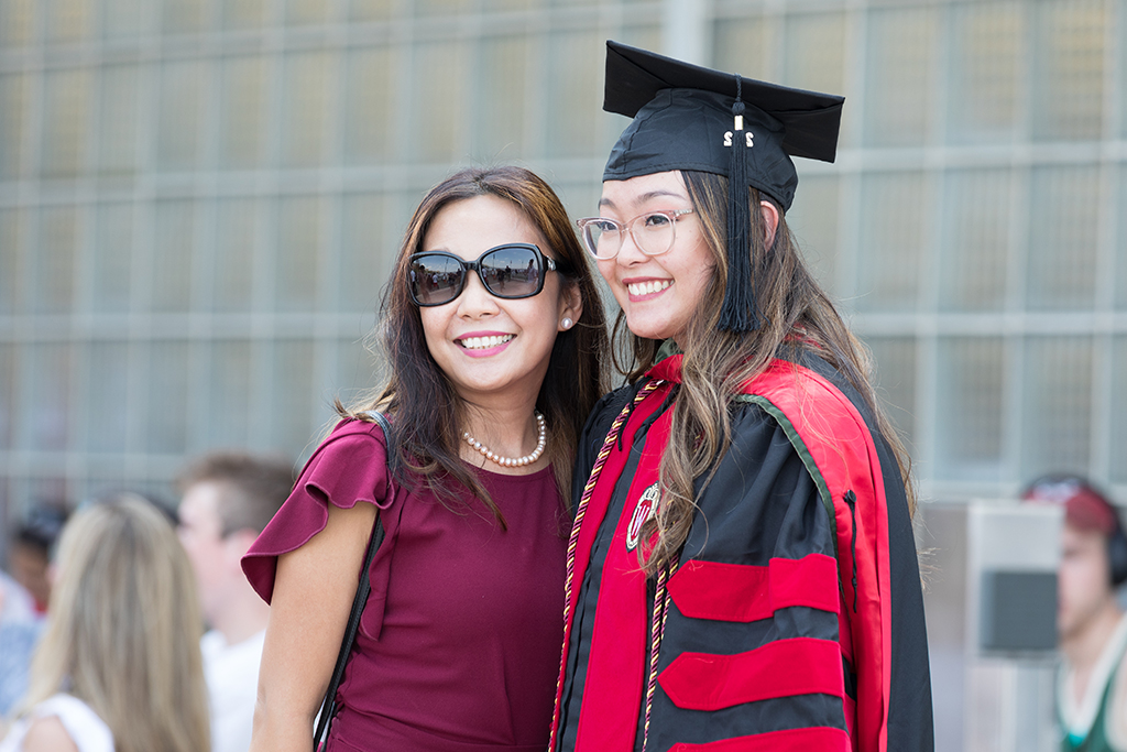 Lorewell Buaya poses for a photo with her mom on the Memorial Union Terrace after the 2022 School of Pharmacy Hooding Ceremony