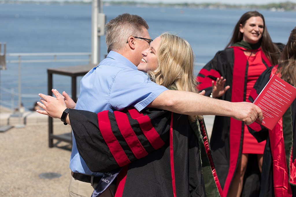 Brianna Filtz enters an embrace with her dad after the 2022 School of Pharmacy Hooding Ceremony at Memorial Union.