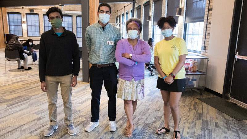 Professor Eva Vivian wearing masks with students in vaccination clinic