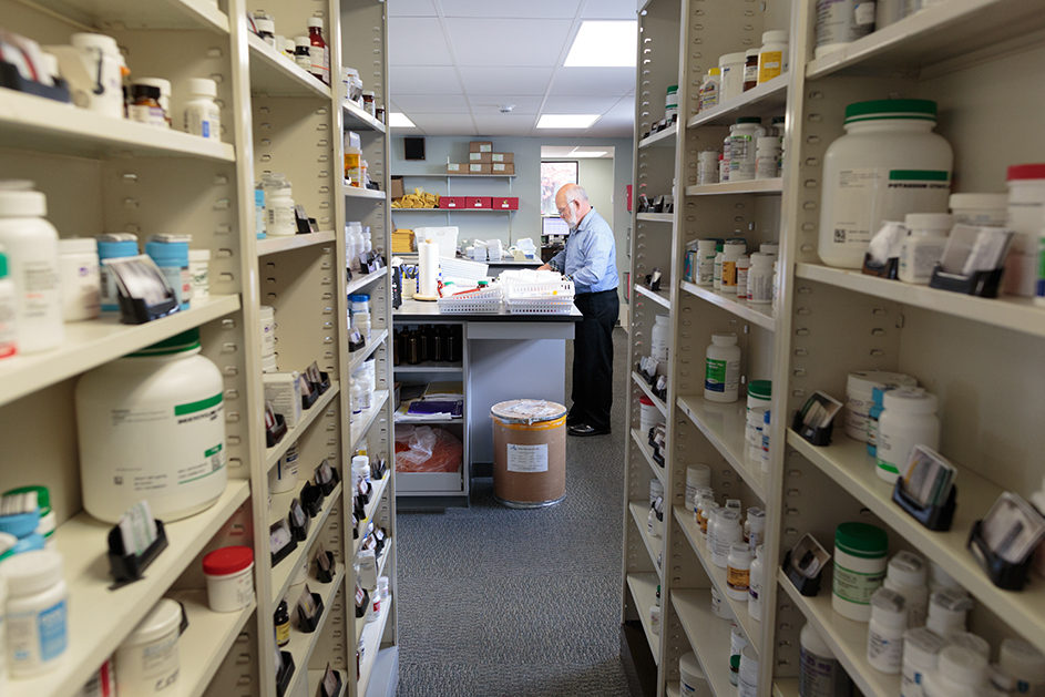 A look inside the Pet Apothecary at prescriptions on shelves and staff member at counter