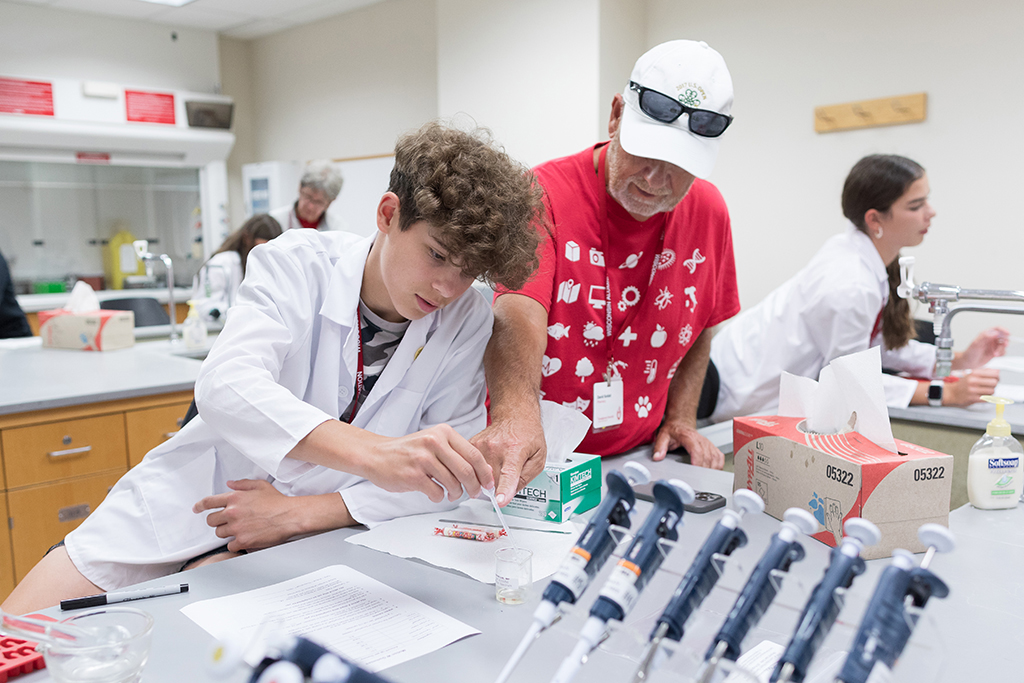 An attendee uses a dropper to add liquid to a mold