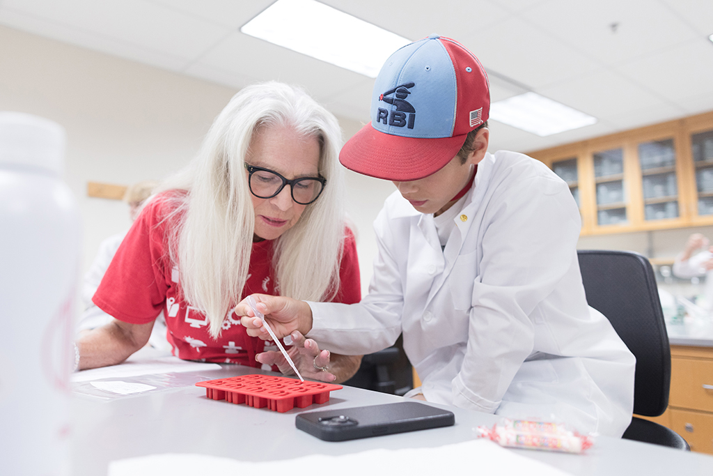 An attendee uses a dropper to add liquid to a mold