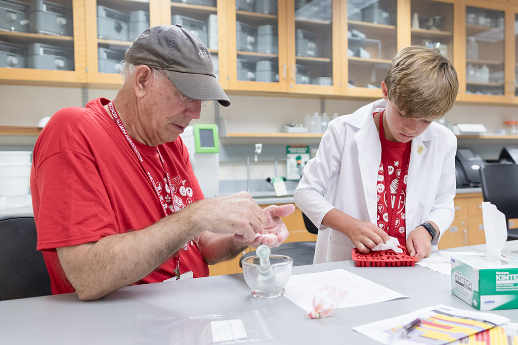 An attendee crushes a white powder in a bowl