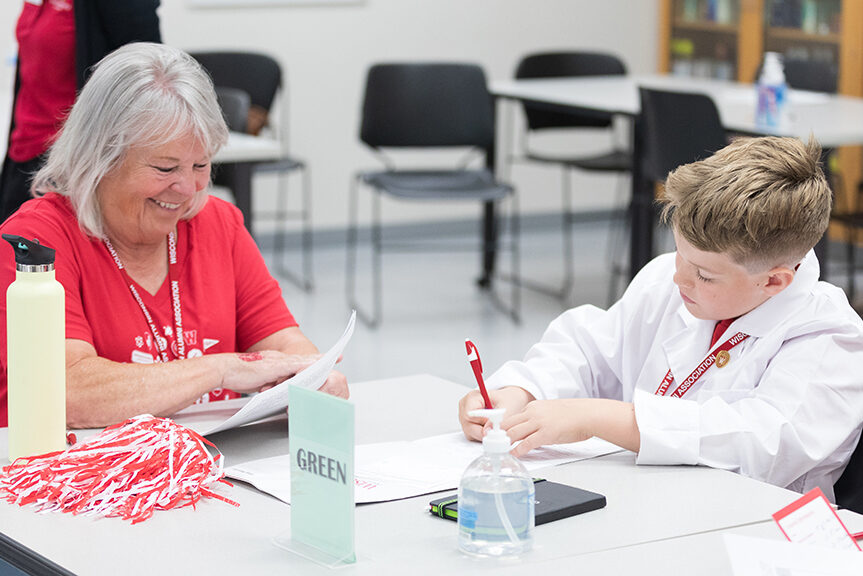 A pair of attendees fill out their worksheets and smile