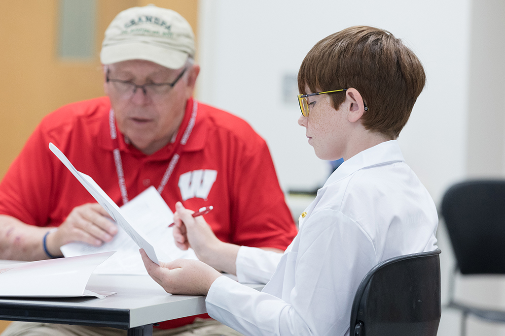 A young male attendee looks at a sheet of paper