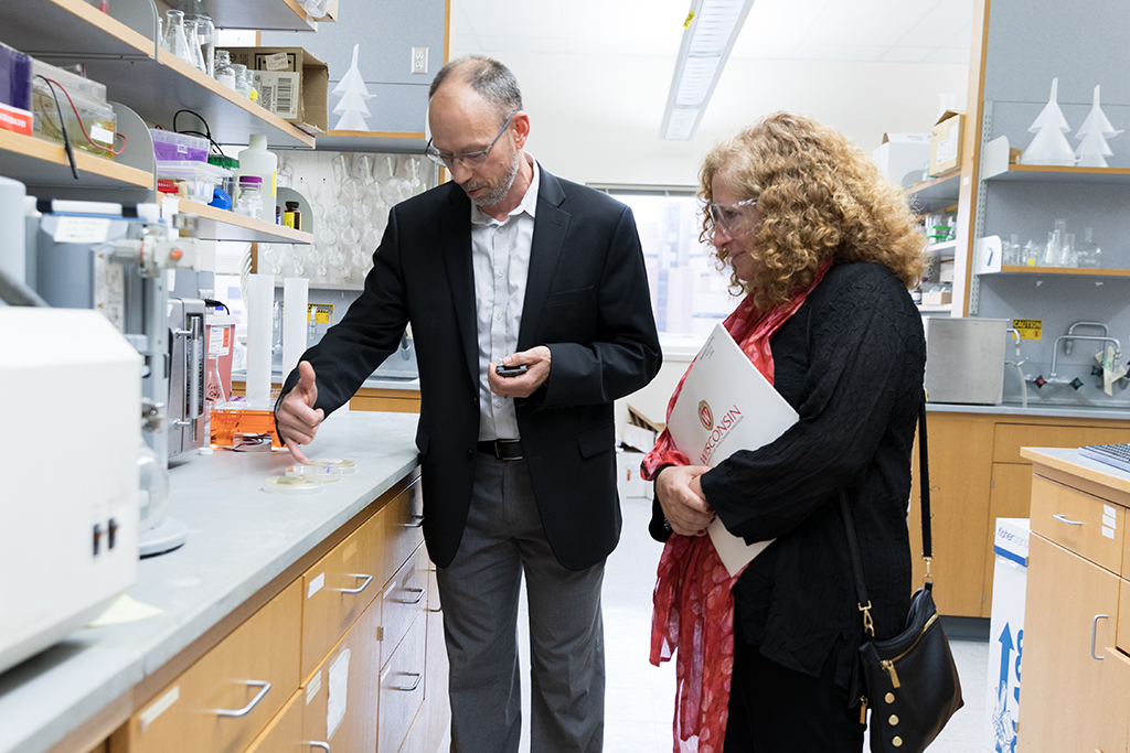 Tim Bugni giving Chancellor Mnookin a tour of the School of Pharmacy, showing her a lab