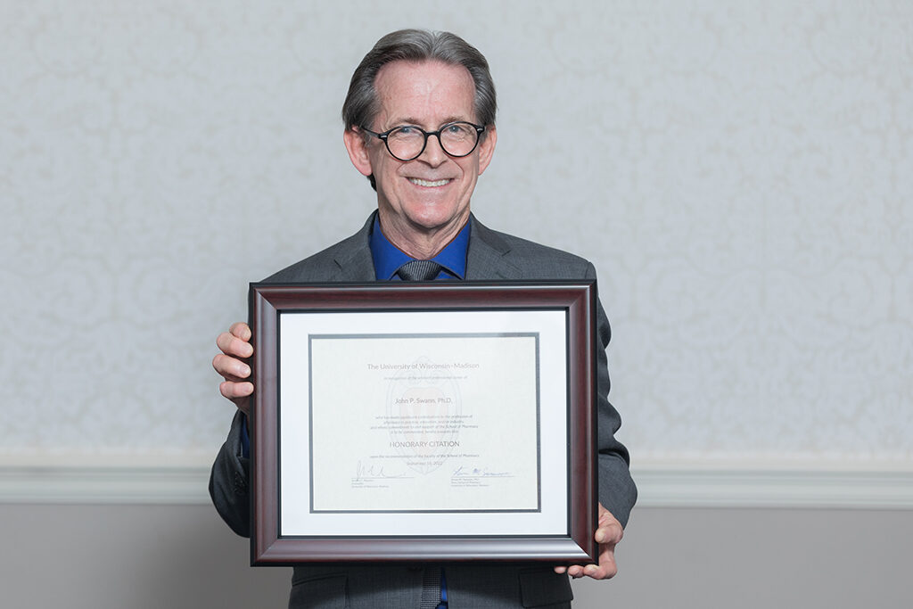 John Swann holding his Citation of Merit award.