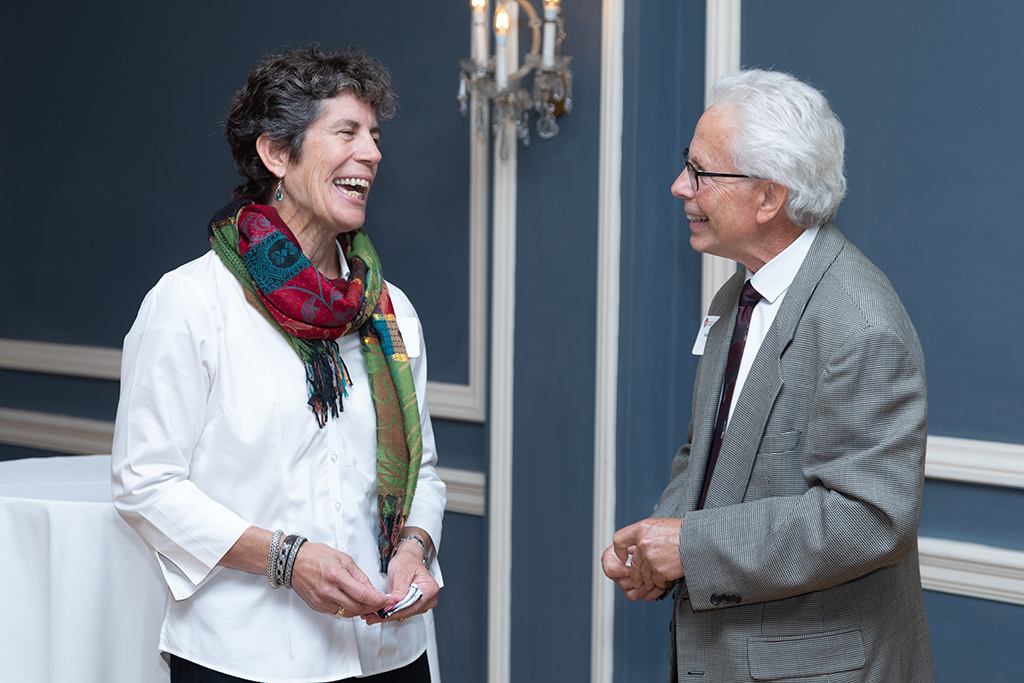Susan Stein smiling in conversation with Bob Breslow.