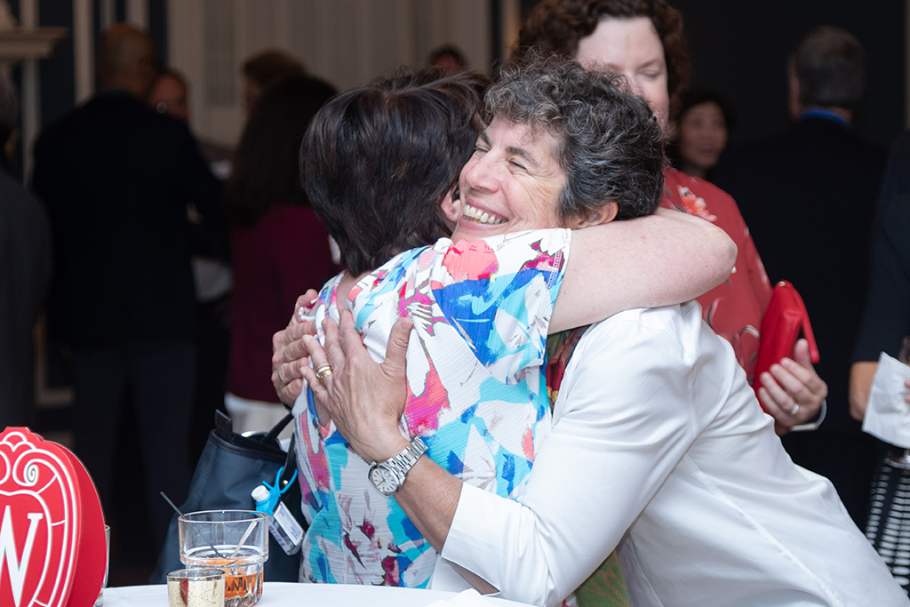 Susan Stein and another attendee embrace.