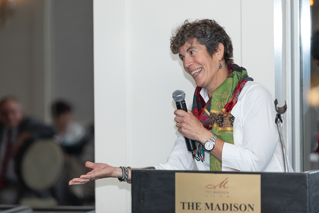 Susan Stein speaking at a podium.