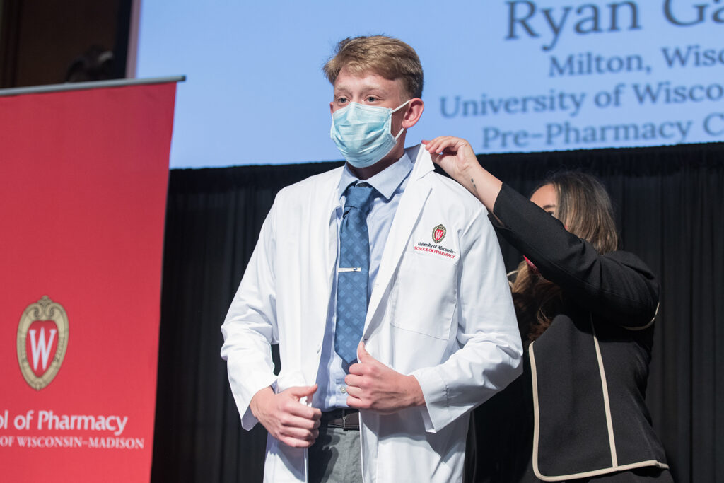 Student wearing their white coat on-stage