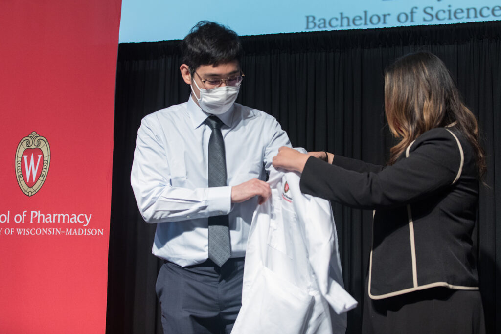 Student wearing their white coat on-stage