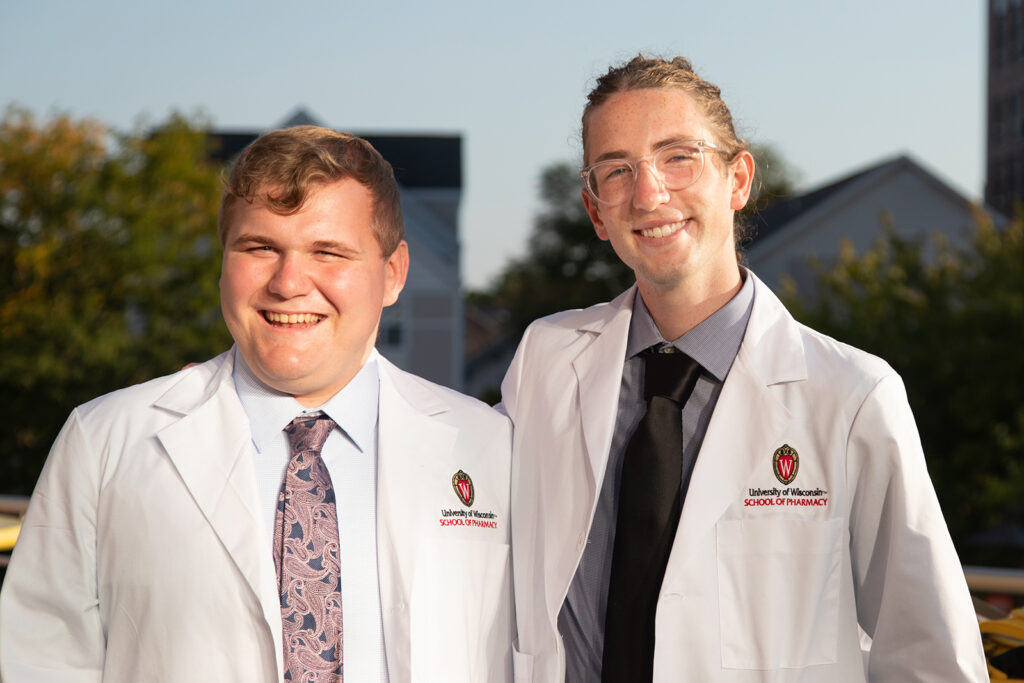 Two pharm students together wearing their white coats after white coat ceremony