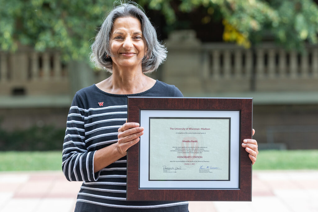 Nita Pandit holding her Citation of Merit award