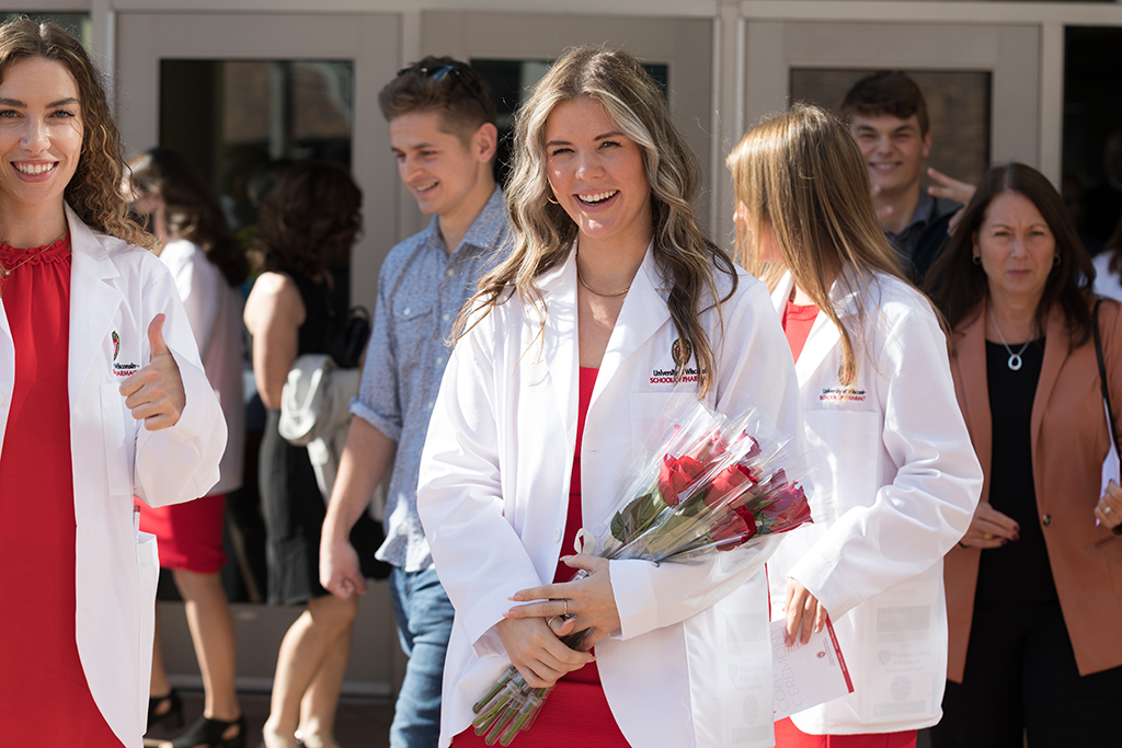 A group of students smile outside after the 2022 White Coat Ceremony.