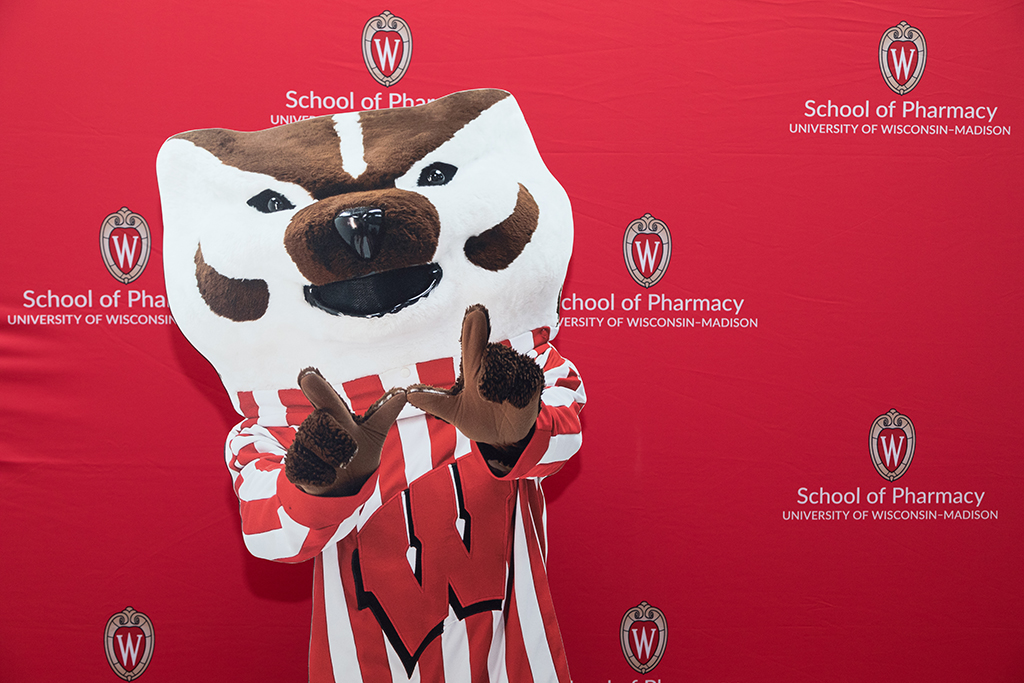 Bucky Badger cardboard cutout in front of School of Pharmacy red backdrop