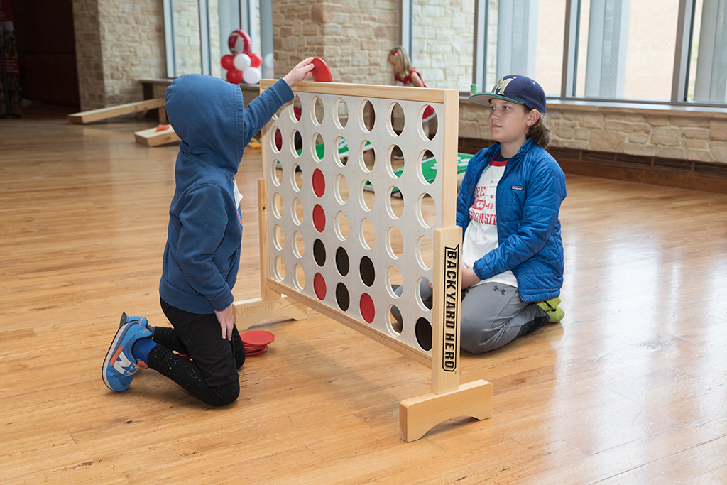 Two kids playing large version of connect 4