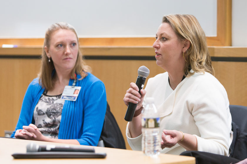 Woman on panel speaking into microphone during career development day