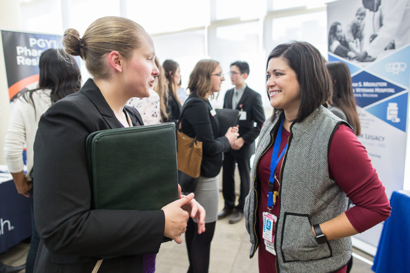 Maria Wopat (PharmD '10) (right) speaking with a student during the School of Pharmacy's 2019 Career Fair.