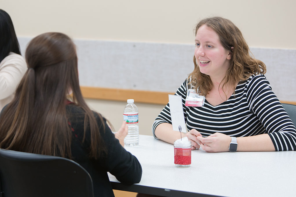 Alumna Olivia Fahey speaking to a current PharmD student at the Roundtable Networking event at the School.