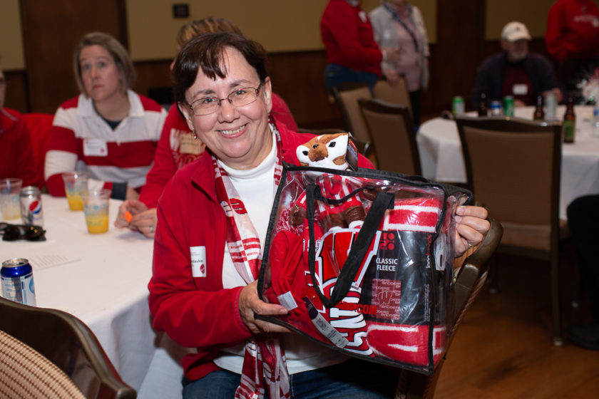 Alumni at the 2019 Tailgate, woman holding bag of badger merch
