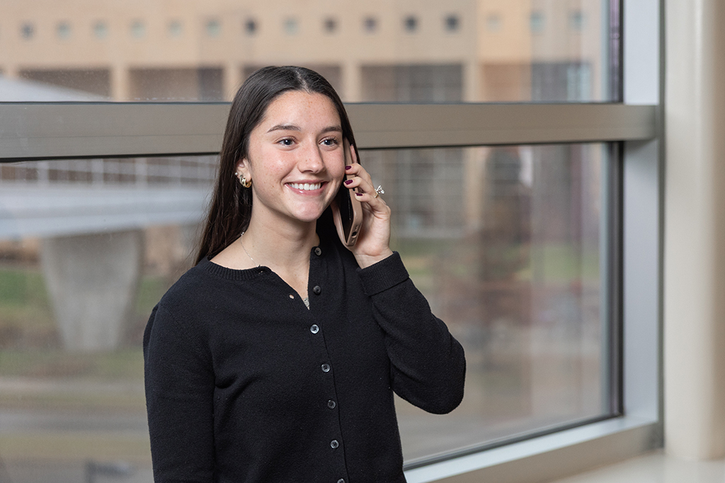 Kira Kirsch speaks on her cellphone in front of a window