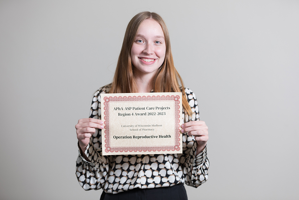 Kelby Drogemueller holding an award certificate for Operation Reproductive Health