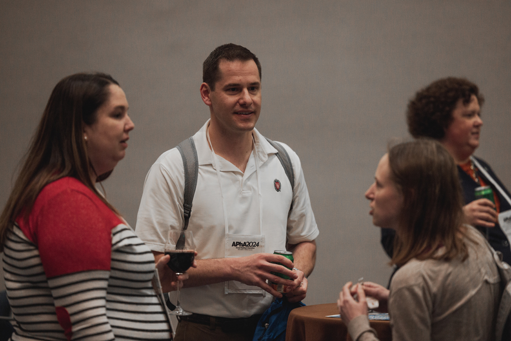 A man listens while two women speak