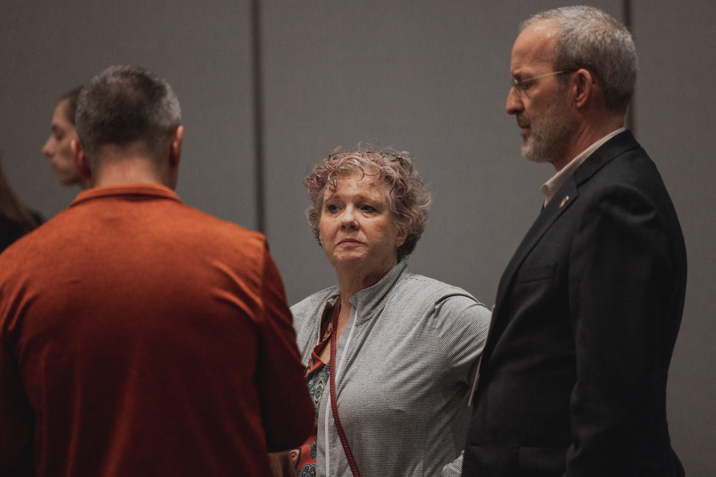 Dave Mott, Nick Olson, and another attendee speak