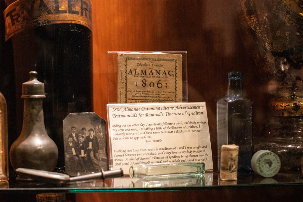 A display featuring a label saying "1806 Almanac Patent Medicine Advertisements Testimonials for Ramrod's Tincture of Gridiron."