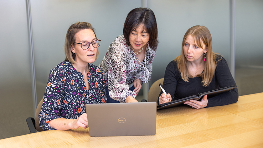 Kate Rotzenberg, Michelle Chui, and Jamie Stone looking at a computer