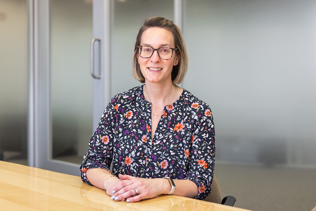 Kate Rotzenberg sits at a table and smiles