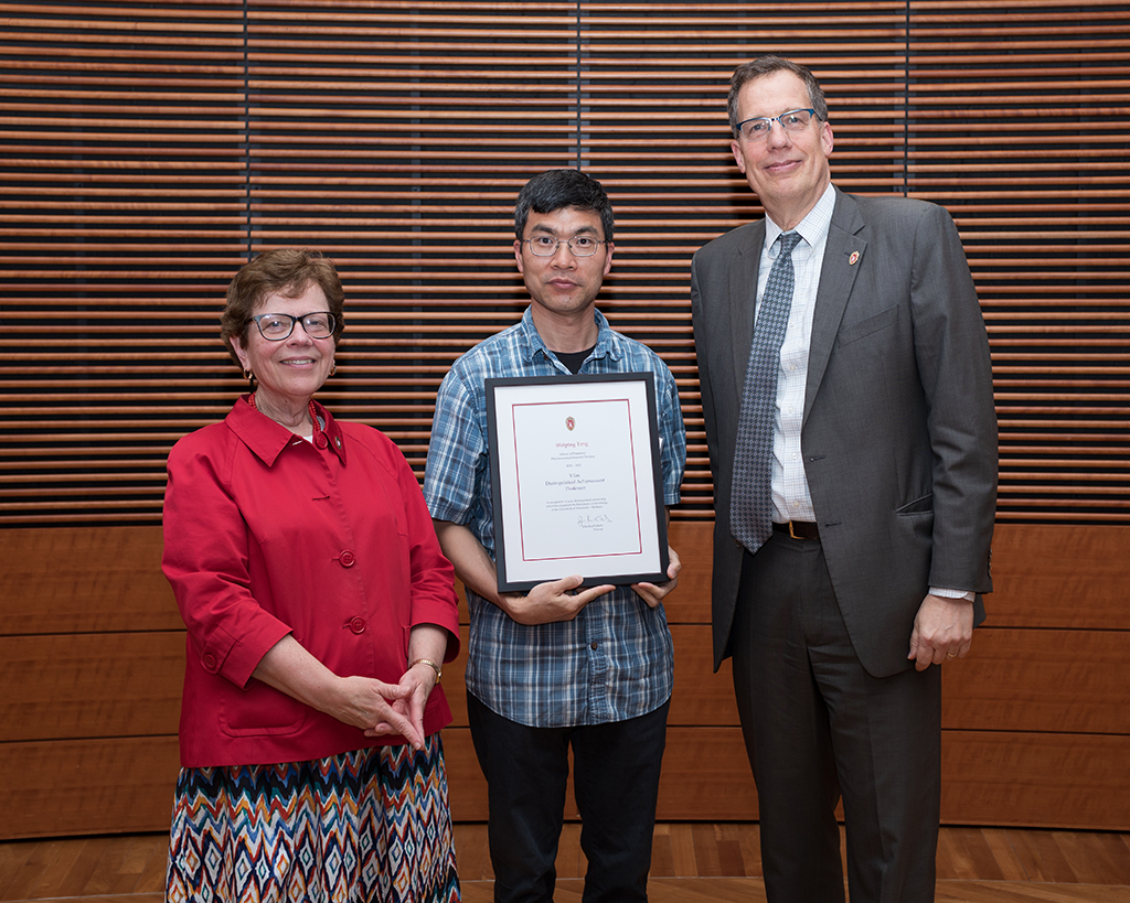 Weiping Tang holds his Vilas award, flanked by Chancellor Becky Blank and interim Chancellor John Karl Scholz.