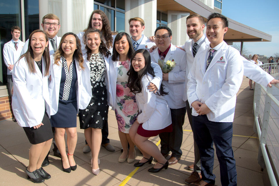 A group of PharmD students pose together outdoors at Union South following their White Coat Ceremony